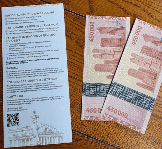 На фото эксклюзивно представлены цифровые векселя А7А5 номиналом по 450 тысяч рублей каждый, сопроводительная инструкция к активам и стертый скрешкод на векселе.